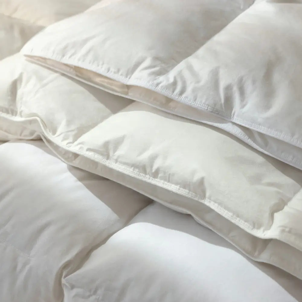 Nahaufnahme der Superior Daunendecke mit übereinanderliegenden, weich gefüllten Kammern und fein vernähter Baumwollhülle, zeigt die hochwertige Verarbeitung und das voluminöse Daunenfüllbild