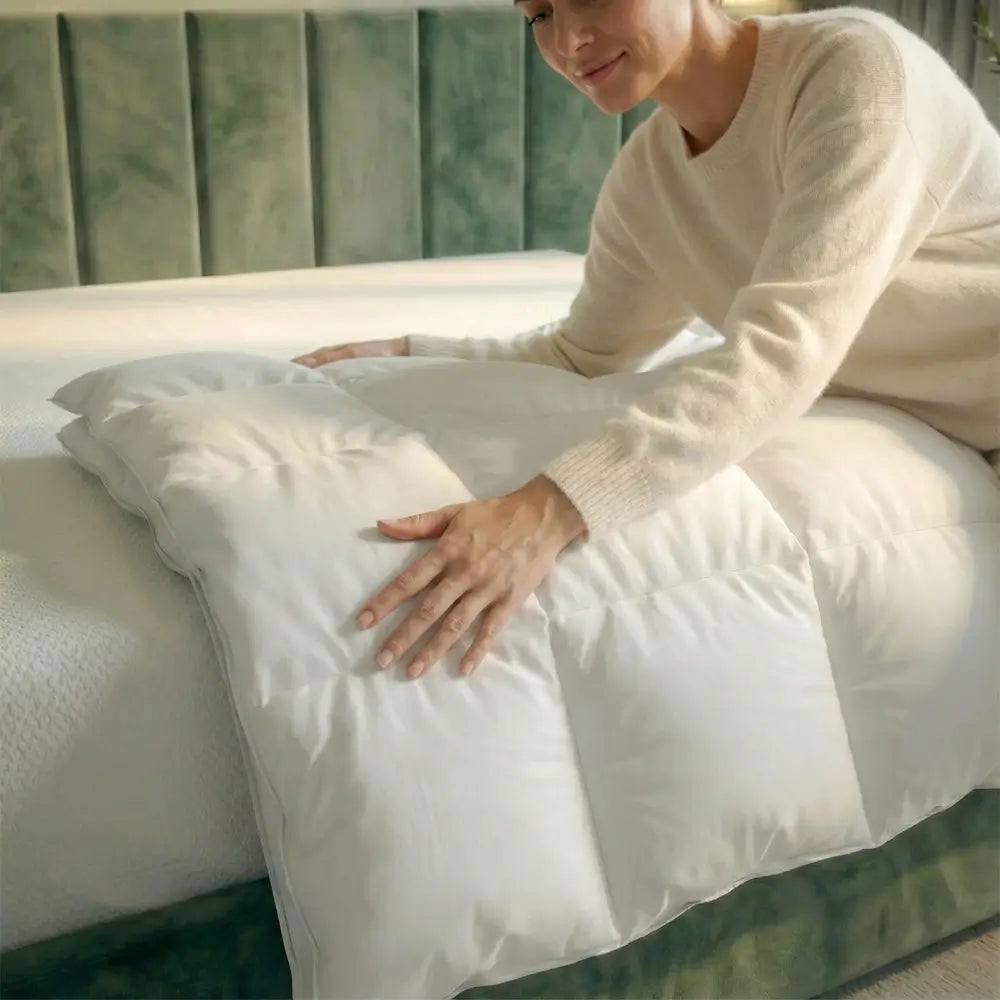 eine Frau streichelt über eine weiße Bettdecke auf einem grünen Bett in einem modernen Schlafzimmer