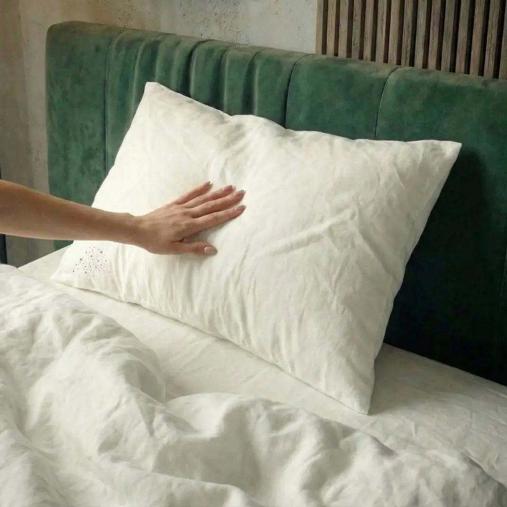 Hand berührt ein veganes Kopfkissen in einem modernen Schlafzimmer