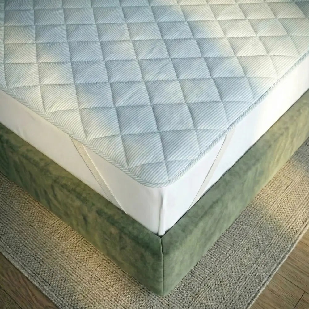 Ecke der TopCool Matratzenauflage mit gesteppter, kühlender Oberfläche, passgenau auf der Matratze liegend für rutschfesten Halt und hohen Schlafkomfort