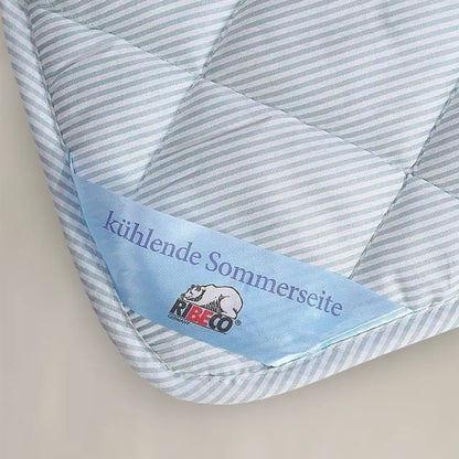 Detail der TopCool Matratzenauflage mit Hinweis ‚kühlende Sommerseite‘, gestreifter Bezug kennzeichnet die temperaturregulierende Oberfläche für erfrischenden Schlafkomfort