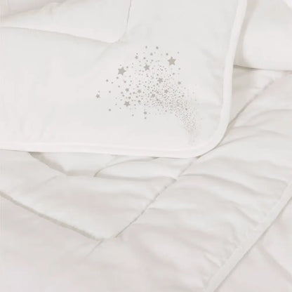 Detailansicht der Essential veganen Faserdecke mit feiner Steppung und dekorativem Sternmotiv auf dem Etikett, gleichmäßig gefüllte synthetische Decke in Weiß