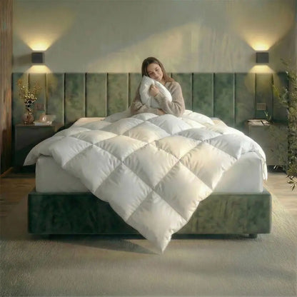 Frau sitzt entspannt im Bett und kuschelt sich in die weiße Premium vegane Decke Polypearls, modernes Schlafzimmer mit grünem Kopfteil und warmer Wandbeleuchtung