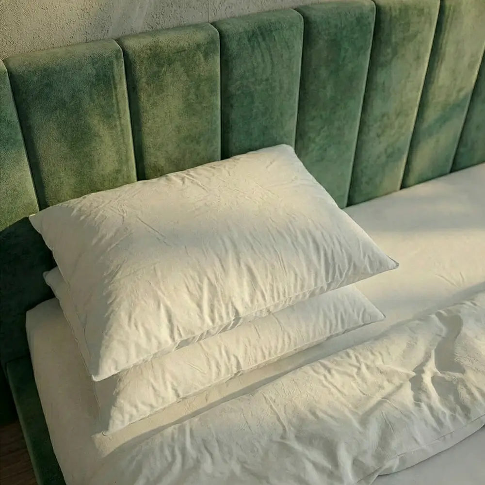 Zwei Premium vegane Faser-Kissen übereinander auf Bett im Schlafzimmer