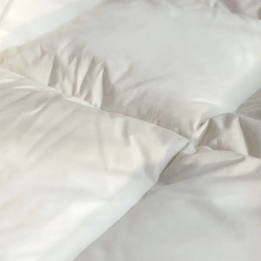 Nahaufnahme der Essential Federdecke mit weichem Bezug und locker gefüllten Kammern für luftigen Schlafkomfort und leichte Wärme