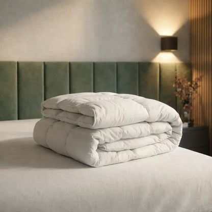 Gefaltete weiße Premium vegane Decke Polypearls auf einem Bett, modernes Schlafzimmer mit grünem Polsterkopfteil und indirekter Wandbeleuchtung